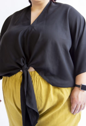 Front view of plus sized model wearing Bow Top in Black Lyocell.