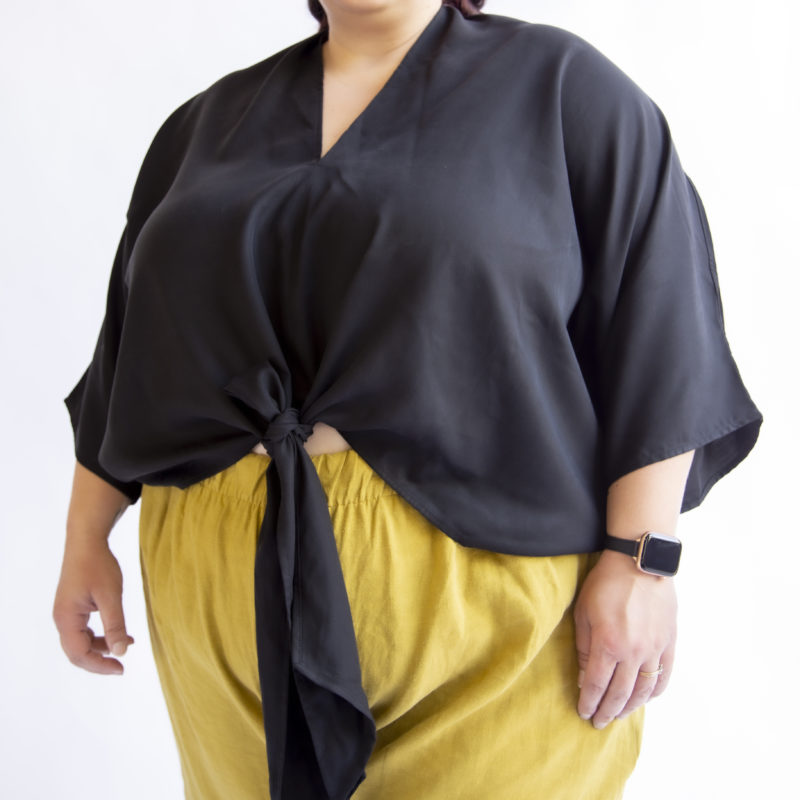 Front view of plus sized model wearing Bow Top in Black Lyocell.