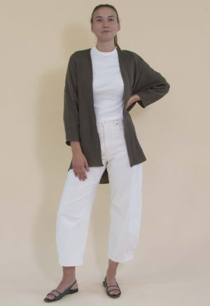 woman in white jeans, white rib top and dark green linen jacket