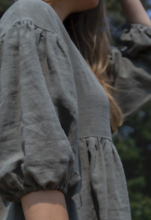 Close up side view of model in Oversized Dress in Moss Linen.