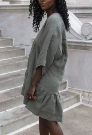 Side view of straight size model wearing Short Tiered Dress in Moss Linen.