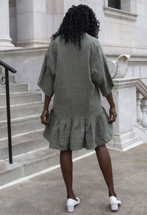 Back view of straight size model wearing Short Tiered Dress in Moss Linen.