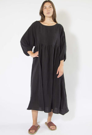 woman standing on white backdrop in black linen midi oversized dress with balloon sleeves