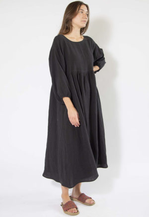 woman standing on white backdrop in black linen midi oversized dress with balloon sleeves