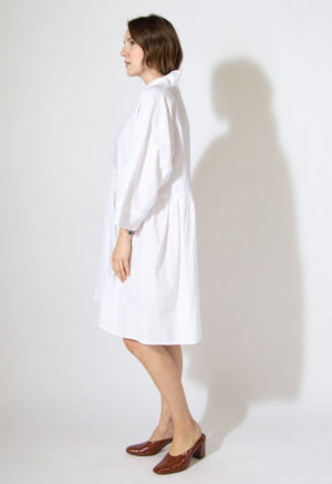 Side view of straight size model wearing sample 528 in white cotton.