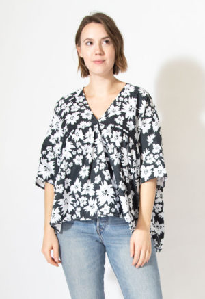 Front view of straight size model wearing v-neck ruffle top in Jungle Floral.
