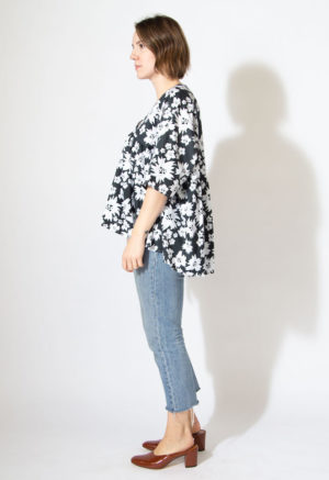 Side view of straight size model wearing v-neck ruffle top in Jungle Floral.