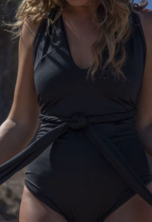 Front view of straight size model wearing Everything One Piece in black.