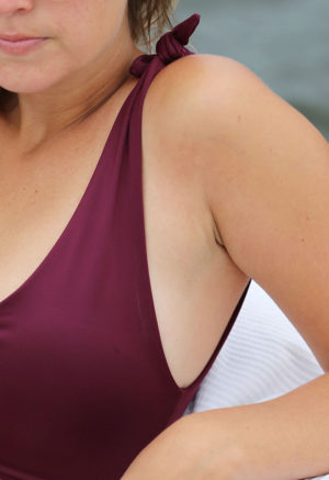 Close up view of straight size model wearing shoulder tie top in fig.