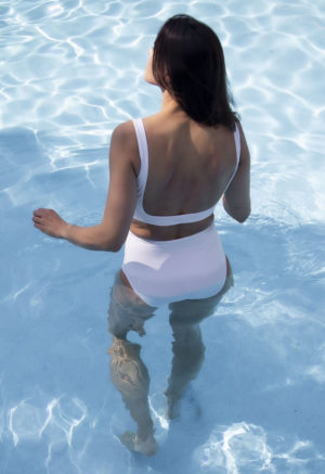 Back view of straight size model wearing Knotted High Waisted Bottoms in white.