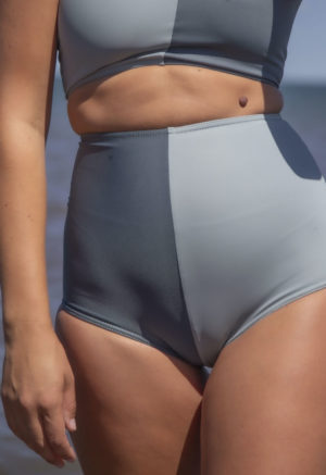 Front view of straight size model wearing Two Tone High Waisted Bikini Bottoms in Eucalyptus and Storm.