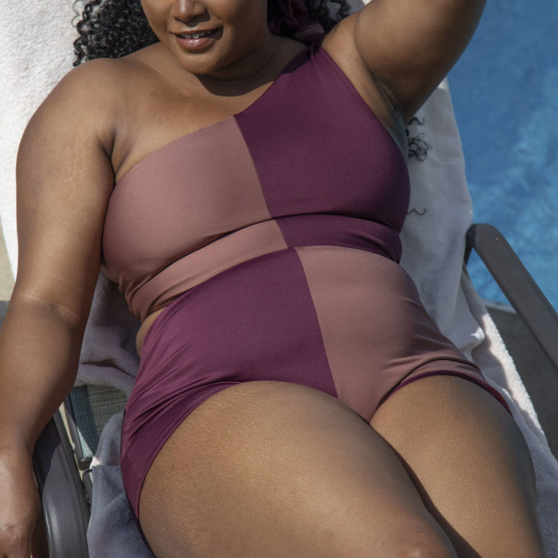 Front view of plus size model wearing Two Tone One Shoulder Tie Top in Chestnut and Fig.