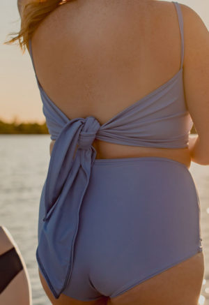 Back view of plus size model wearing wrap top in Periwinkle.
