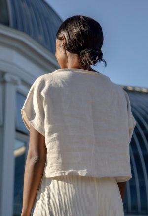 Back view of straight size model wearing Boatneck Crop Top in Oatmeal Linen.
