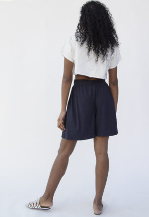 Back view of straight size model wearing Boatneck Crop Top in Oatmeal Linen.