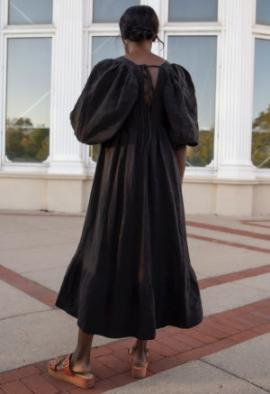 Back view of straight size model wearing Ruffle Midi Dress in Black Linen.