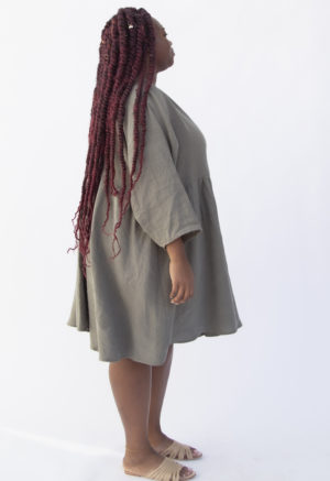Side view of plus size model wearing Short Oversized Dress in Moss Linen.