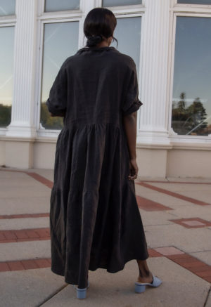 Back view of straight size model wearing Tiered Lapel Dress in Black Linen.