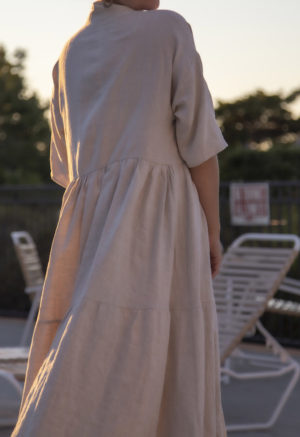 Back view of straight size model wearing Tiered Lapel Dress in Oatmeal Linen.