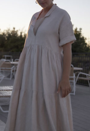 Side view of straight size model wearing Tiered Lapel Dress in Oatmeal Linen.
