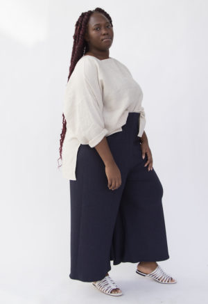 Side view of plus size model wearing Tunic Pullover in Oatmeal Linen tucked in.