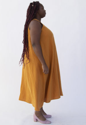 Side view of plus size model wearing Reversible Scoop Dress in Saffron Linen.