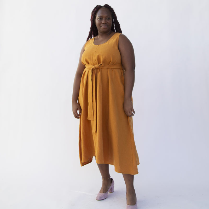 Front view of plus size model wearing Reversible Scoop Dress in Saffron Linen with a sash.