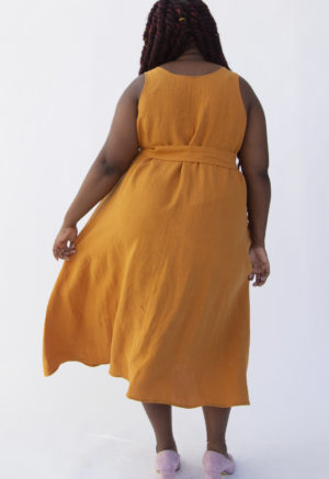 Back view of plus size model wearing Reversible Scoop Dress in Saffron Linen with a sash.