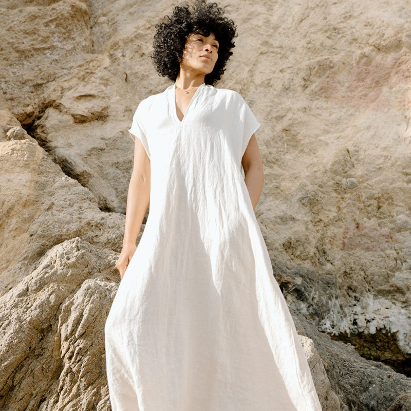 woman on the beach in cream linen v-neck short sleeve midi dress