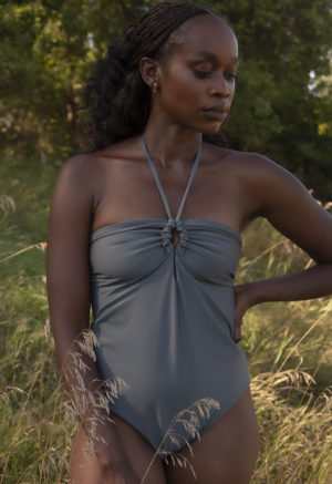 Front view of straight size model in Eucalyptus Keyhole Tie One Piece standing outside by trees.