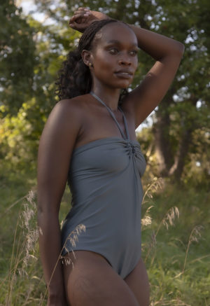 Front/side view of straight size model in Eucalyptus Keyhole Tie One Piece standing outside by trees.
