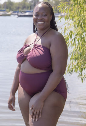 Front/side view of plus size model in Fig Retro Fit Bottoms standing in lake.