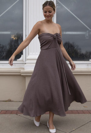Front view of a straight size model in the Mauve Rib Everything Tank Dress, standing, standing outside in front of large windows.
