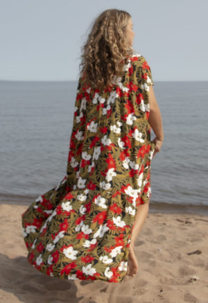 Back view of straight size model in Island Floral Double V Tiered Maxi Dress standing on beach with lake in background.