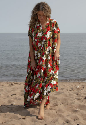 Front view of straight size model in Island Floral Double V Tiered Maxi Dress standing on beach with lake in background.