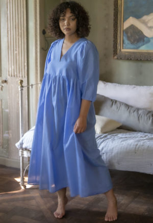Front view of straight size model in Cerulean Blue Balloon Sleeve Midi Dress standing in front of daybed.