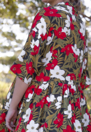 Close-up back view of straight size model wearing Island Floral Tiered Lapel Dress.