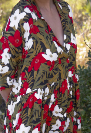 Close-up front/side view of straight size model wearing Island Floral Tiered Lapel Dress.