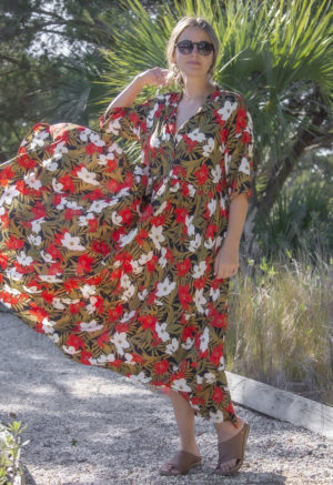 Front view of straight size model wearing Island Floral Tiered Lapel Dress standing on path with bushes behind her.