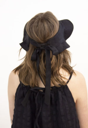 Back view of straight size model wearing Black Tie Visor Hat.