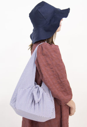 Side view of straight size model wearing Navy Sun Hat.