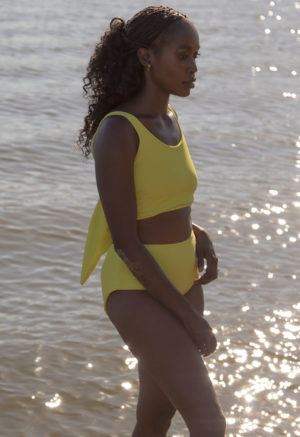 Side view of straight size model wearing Margarita Scoop Wrap Top and Margarita Hipster Bottoms standing with lake in background.