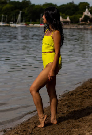 Side view of straight size model wearing Margarita Wrap Top and Margarita High-Waisted Bikini Bottoms standing on shoreline.