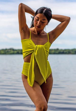 Front view of straight size model wearing Margarita Wrap Top and Margarita High-Waisted Bikini Bottoms standing with lake in background.
