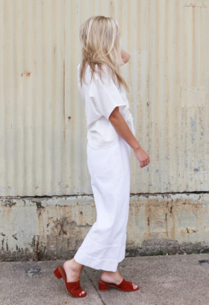 Side view of straight size model wearing White Easy Wide-Leg Pants with Back Pockets.