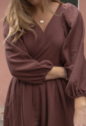 Close-up front view of straight size model wearing Raisin Gauze Reversible Wrap Dress.