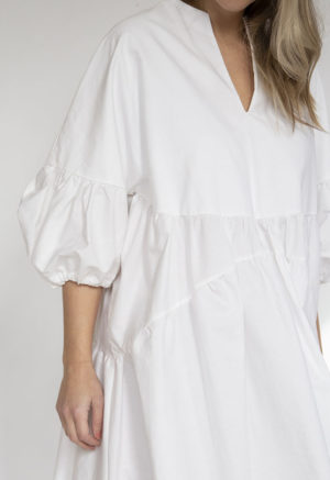 Close-up front view of straight size model wearing White Circle Midi Dress.