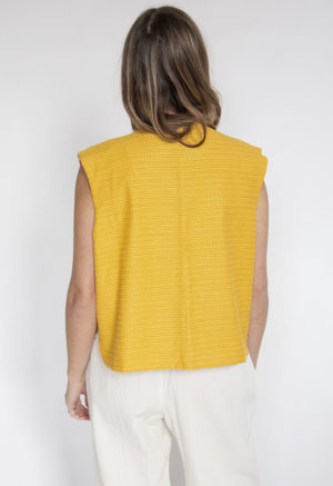 Back view of straight size model wearing Bright Marigold Reversible Vest.