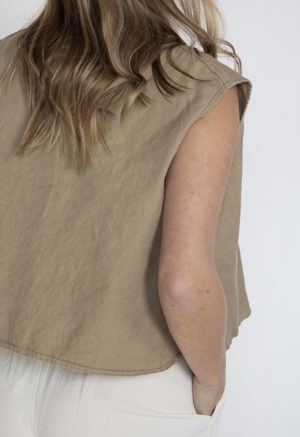 Back view of straight size model wearing Nomad Button Vest.