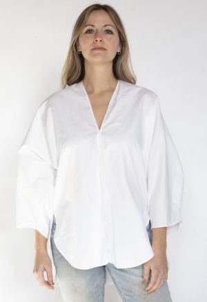 Front view of straight size model wearing White Double V Tunic Top.